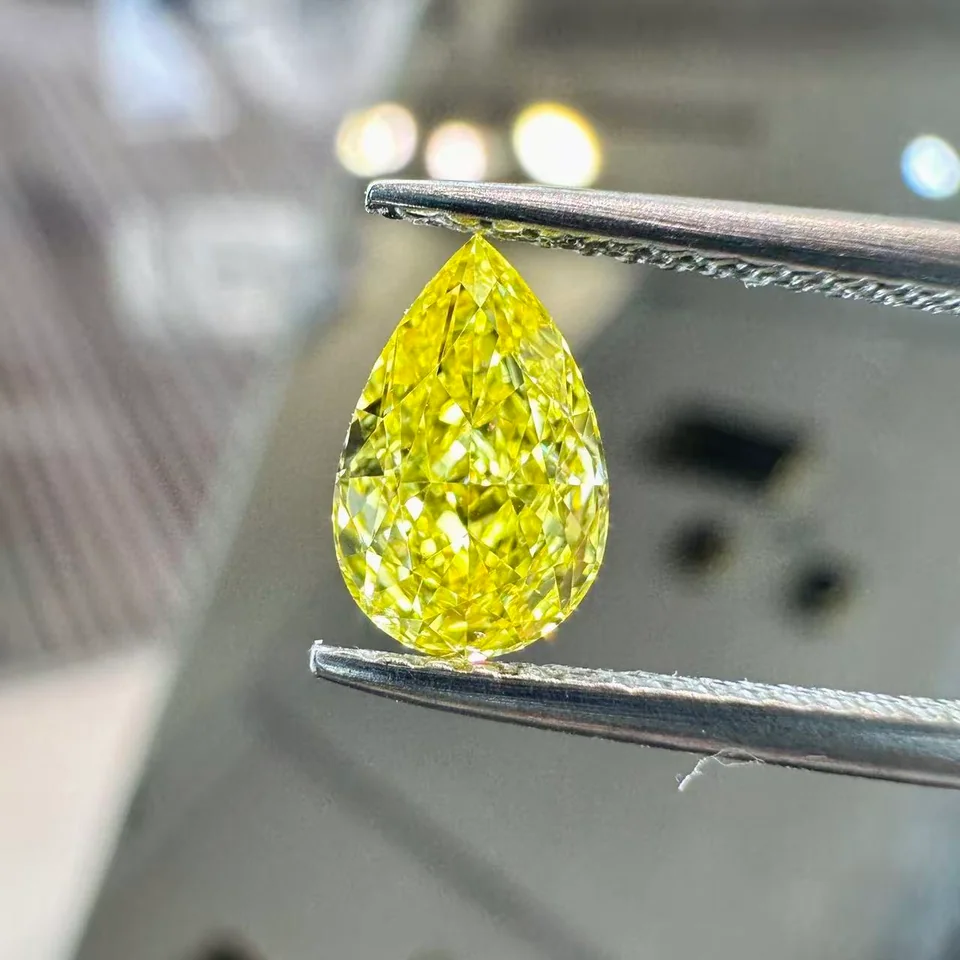 Yellow pear-shaped diamond held in tweezers, from DiamovaLab supplied photographs